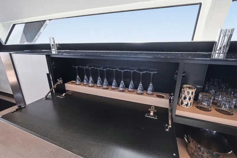 One Spin 3 Yacht Photos Pics Luxurious bar area on a 2019 Pershing 9X yacht with glassware display.