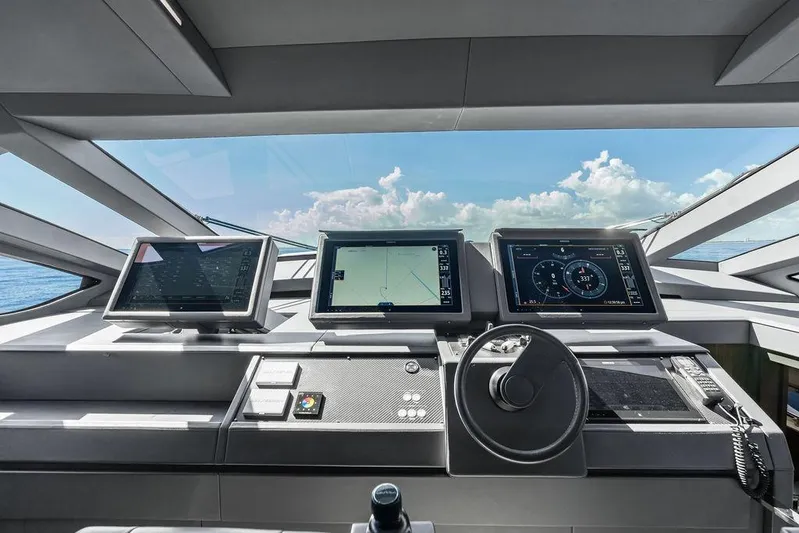 One Spin 3 Yacht Photos Pics Control panel of 2019 Pershing 9X yacht with navigation screens and steering wheel.