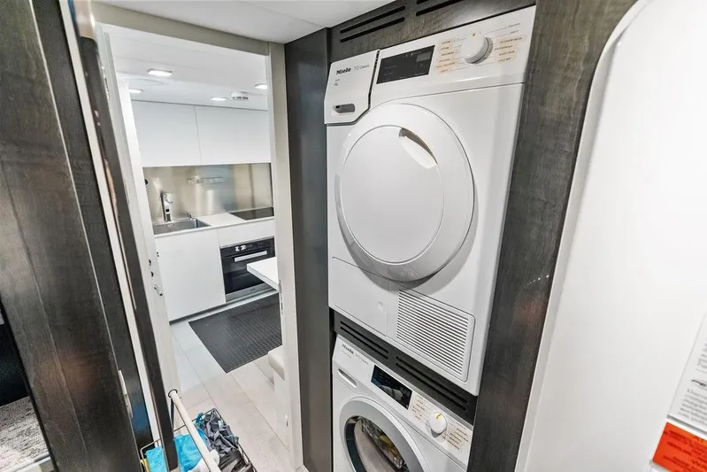 One Spin 3 Yacht Photos Pics Laundry area and modern kitchen inside a 2019 Pershing 9X yacht.