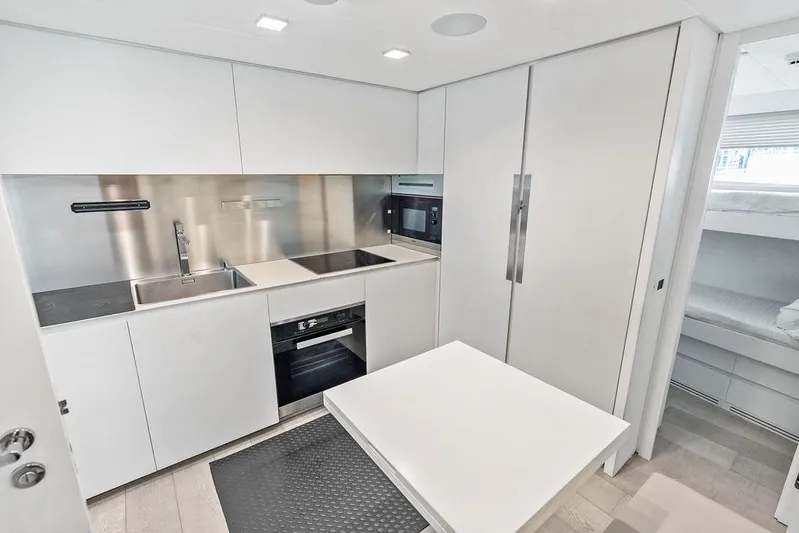 One Spin 3 Yacht Photos Pics Modern kitchen interior of 2019 Pershing 9X yacht with sleek white cabinetry.