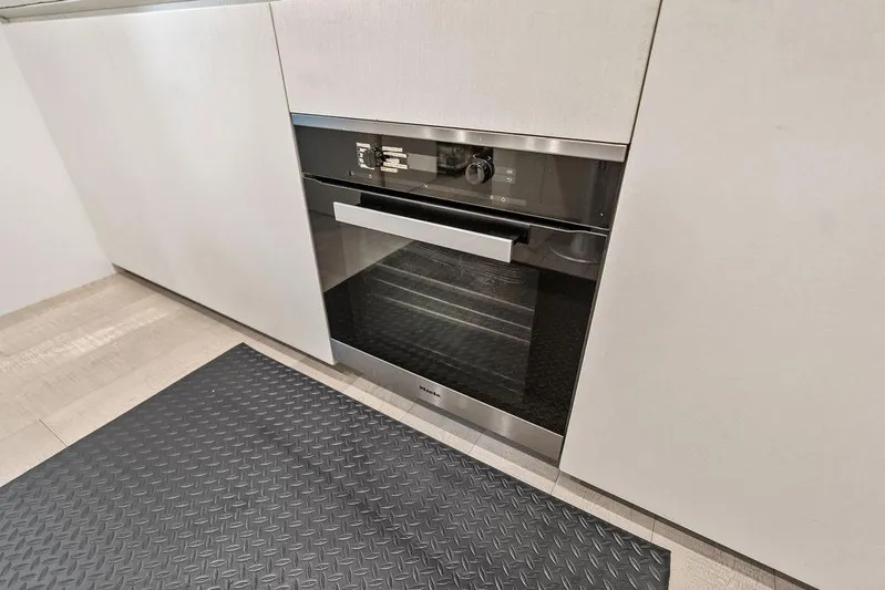 One Spin 3 Yacht Photos Pics Modern kitchen with built-in oven, sleek cabinetry, and textured floor mat.