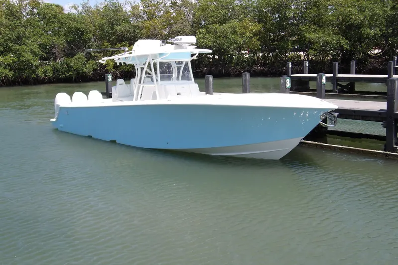  Yacht Photos Pics 2022 SeaVee 370z boat docked in calm waters, surrounded by lush greenery.