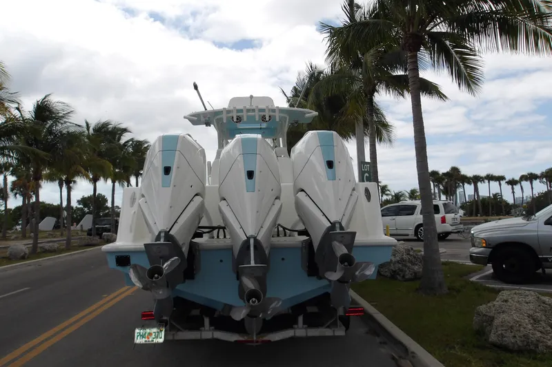  Yacht Photos Pics 2022 SeaVee 370z boat with triple outboard engines on a trailer, surrounded by palm trees.