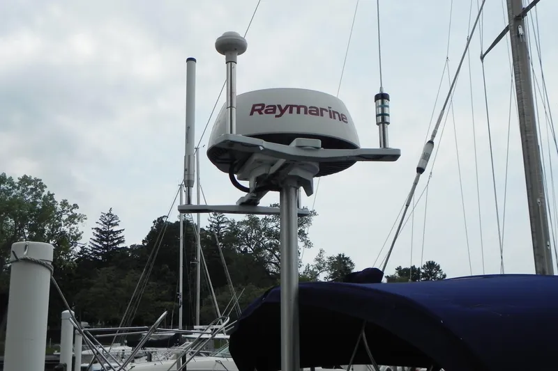 Cricket Yacht Photos Pics Raymarine radar on 1988 Tartan 40 sailboat, docked with masts and trees in background.