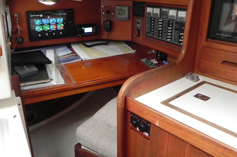 Cricket Yacht Photos Pics Navigation station inside a 1988 Tartan 40 sailboat, featuring charts and electronic equipment.