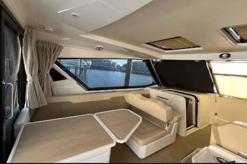  Yacht Photos Pics Interior of 2022 Aquila 36 Cruiser with seating and table, overlooking water.