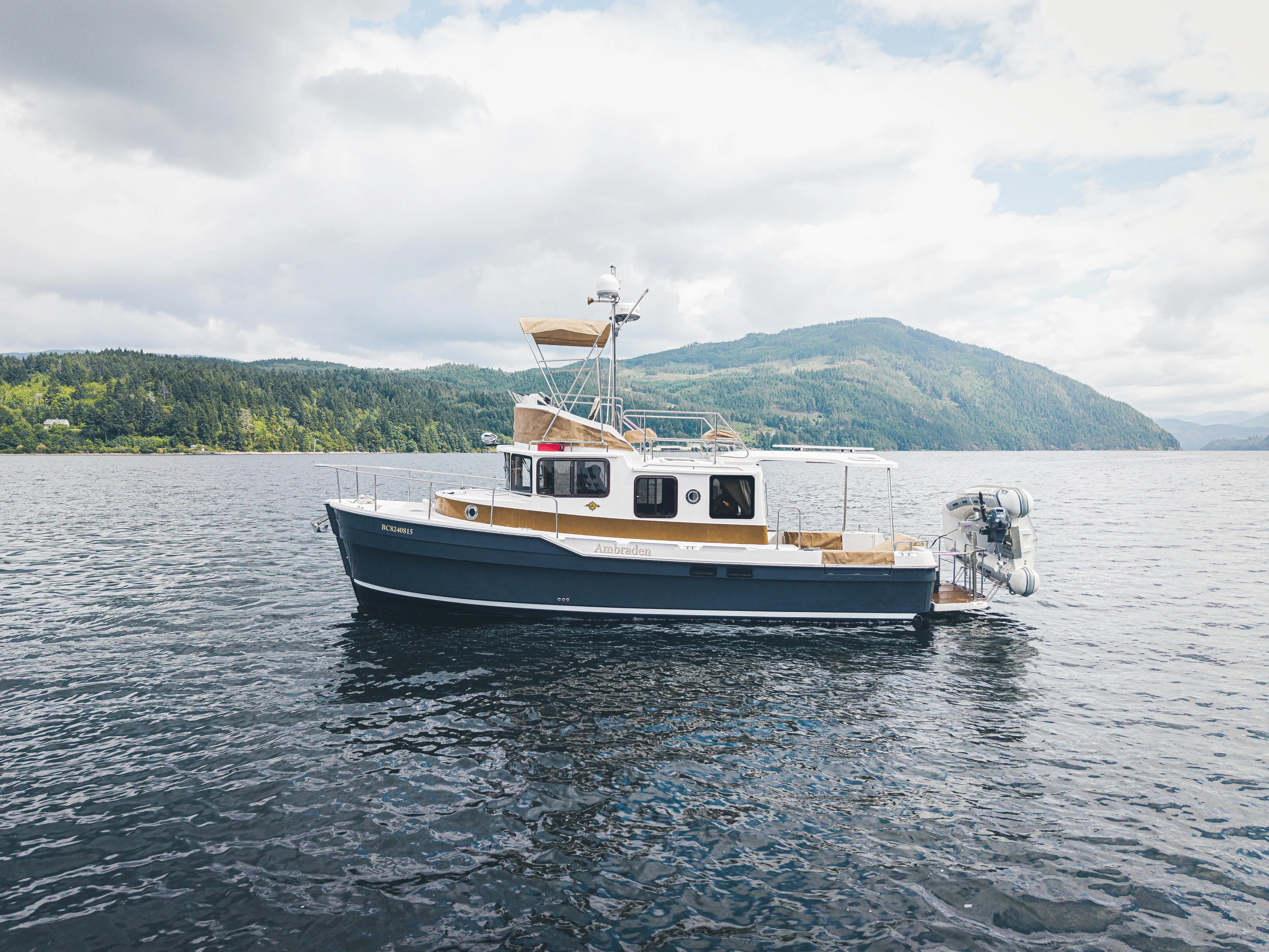 Ambraden Yacht Photos Pics 2022 Ranger Tugs R-31 CB boat on scenic lake with forested hills in background.