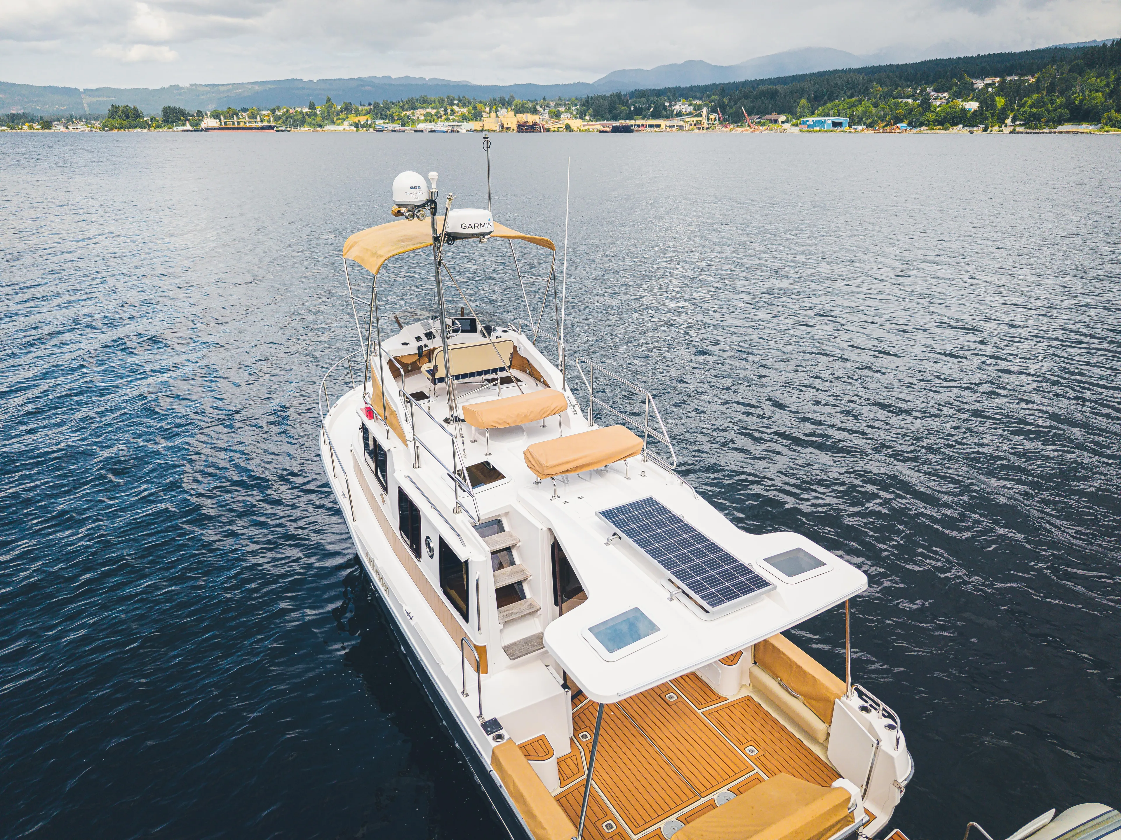 Ambraden Yacht Photos Pics 2022 Ranger Tugs R-31 CB boat on calm water, featuring solar panels and spacious deck.