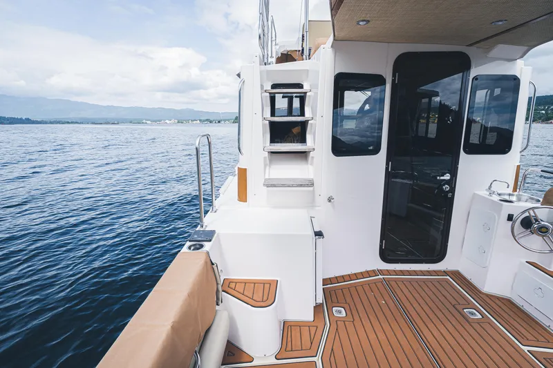 Ambraden Yacht Photos Pics 2022 Ranger Tugs R-31 CB boat deck with teak flooring, overlooking serene waters.