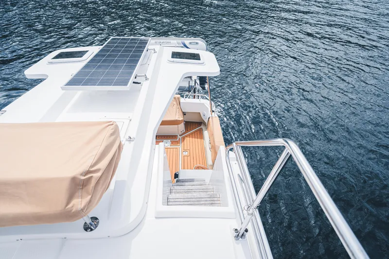 Ambraden Yacht Photos Pics 2022 Ranger Tugs R-31 CB boat with solar panel, wooden deck, and water view.