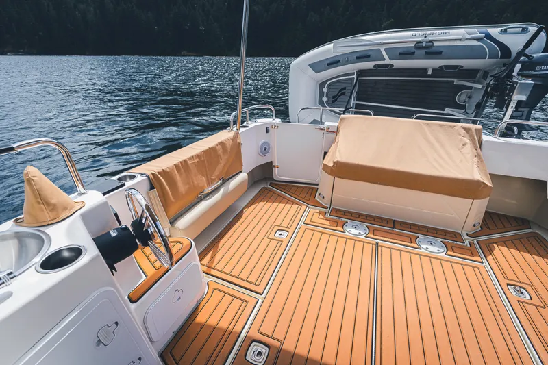 Ambraden Yacht Photos Pics 2022 Ranger Tugs R-31 CB boat deck with teak flooring and seating, on a serene lake.