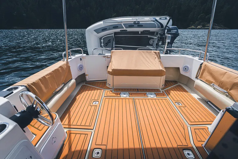 Ambraden Yacht Photos Pics 2022 Ranger Tugs R-31 CB boat deck with seating, on a serene lake.