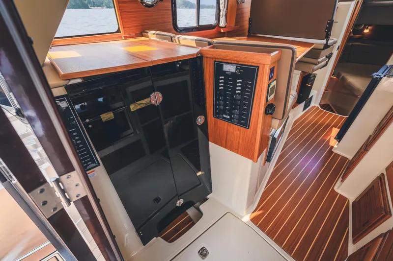 Ambraden Yacht Photos Pics Interior of 2022 Ranger Tugs R-31 CB, featuring wood paneling and control panel.