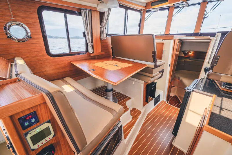Ambraden Yacht Photos Pics 2022 Ranger Tugs R-31 CB interior with wood accents and seating area.