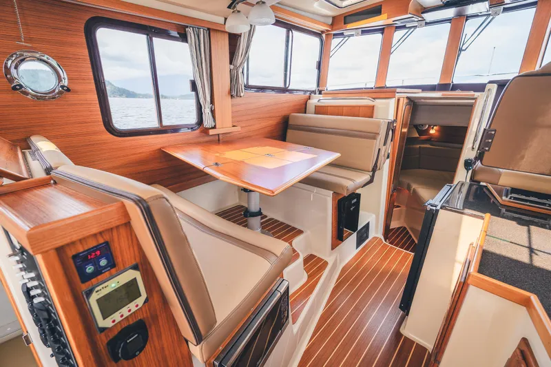 Ambraden Yacht Photos Pics Interior of 2022 Ranger Tugs R-31 CB, featuring wood accents and comfortable seating.