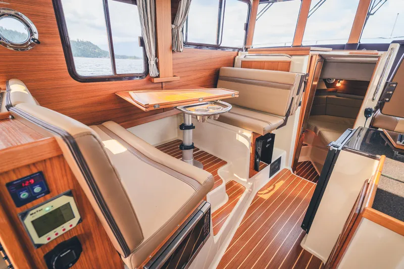 Ambraden Yacht Photos Pics 2022 Ranger Tugs R-31 CB interior with wood accents and seating area.
