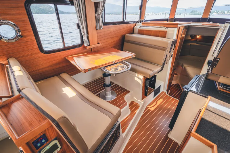 Ambraden Yacht Photos Pics 2022 Ranger Tugs R-31 CB interior with wood finish and seating area.