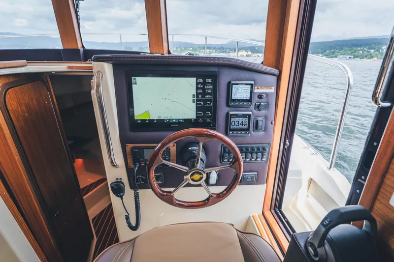 Ambraden Yacht Photos Pics 2022 Ranger Tugs R-31 CB helm with navigation display and wooden steering wheel.