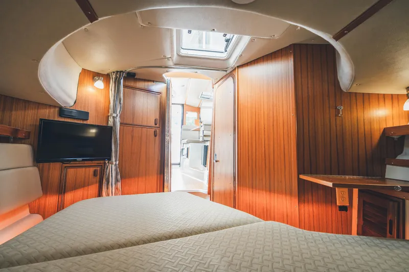 Ambraden Yacht Photos Pics Interior of 2022 Ranger Tugs R-31 CB, featuring cozy cabin with wood paneling and TV.