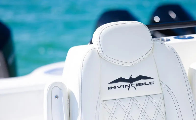  Yacht Photos Pics Invincible 35 Catamaran 2025, white seat detail with logo, ocean background.