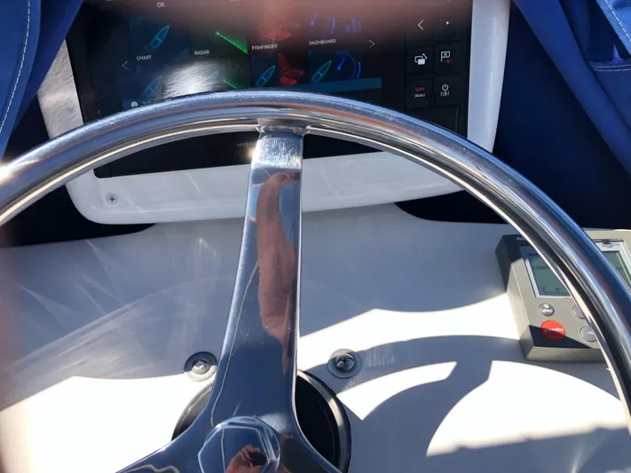 Reel Busy Yacht Photos Pics Steering wheel of a 2006 Tiara Yachts 3800 Open with control panel.