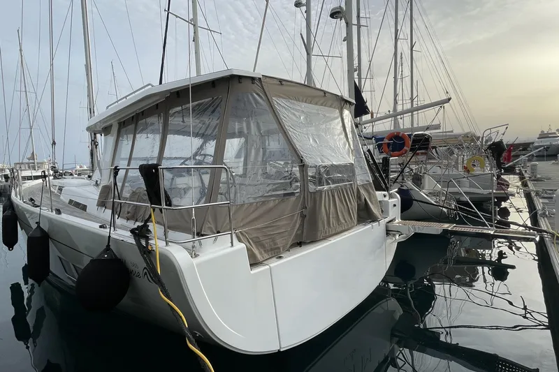  Yacht Photos Pics 2018 Hanse 588 yacht docked at marina, featuring covered cockpit and sleek design.