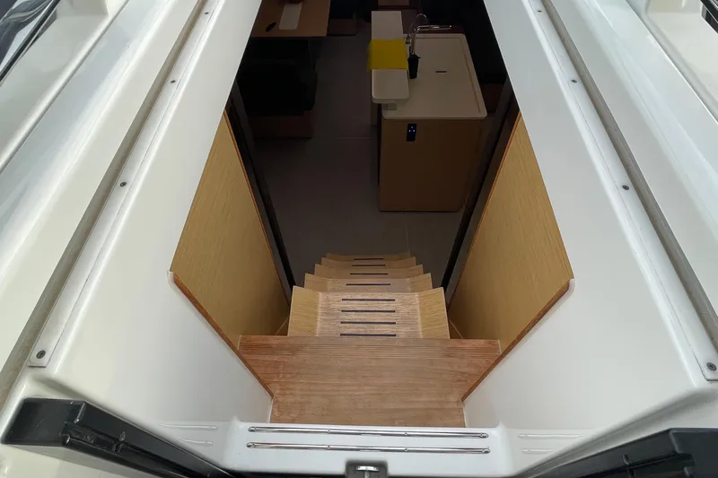  Yacht Photos Pics Interior view of 2018 Hanse 588 yacht, featuring wooden stairs leading to the cabin.