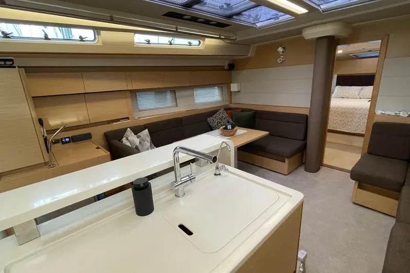  Yacht Photos Pics Luxurious interior of 2018 Hanse 588 yacht with modern kitchen and cozy seating area.