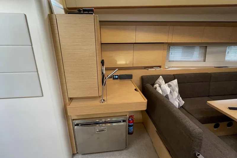  Yacht Photos Pics Interior of 2018 Hanse 588 yacht with modern wood cabinetry and cozy seating area.