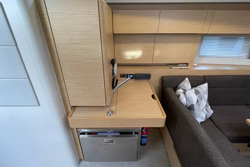  Yacht Photos Pics Interior of 2018 Hanse 588 yacht with modern wood cabinetry and cozy seating area.