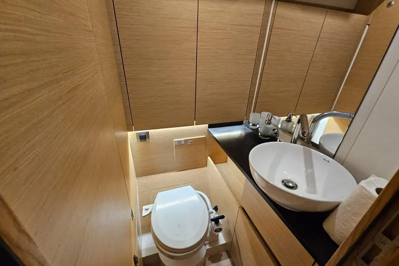  Yacht Photos Pics Luxurious bathroom in 2018 Hanse 588 yacht with modern fixtures and wooden cabinetry.