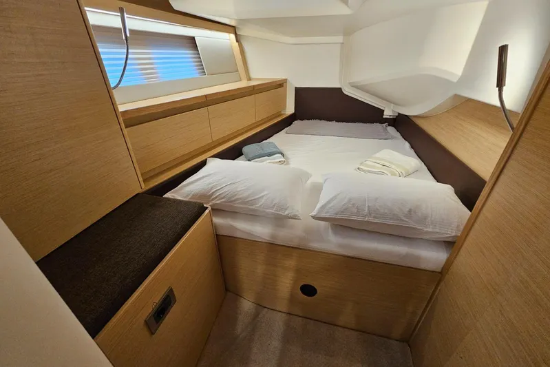  Yacht Photos Pics Luxurious cabin interior of 2018 Hanse 588 yacht with cozy bed and wooden finish.