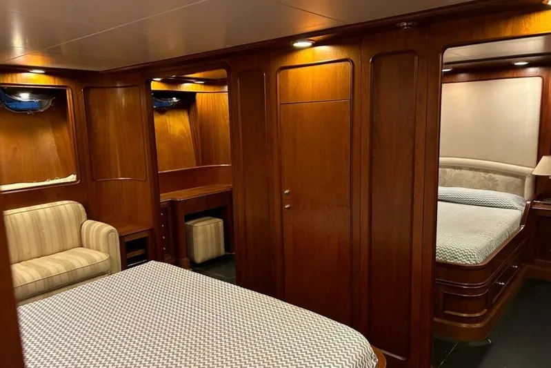  Yacht Photos Pics Luxurious wooden interior of 1998 Sanlorenzo 82 yacht with cozy seating and elegant bedding.