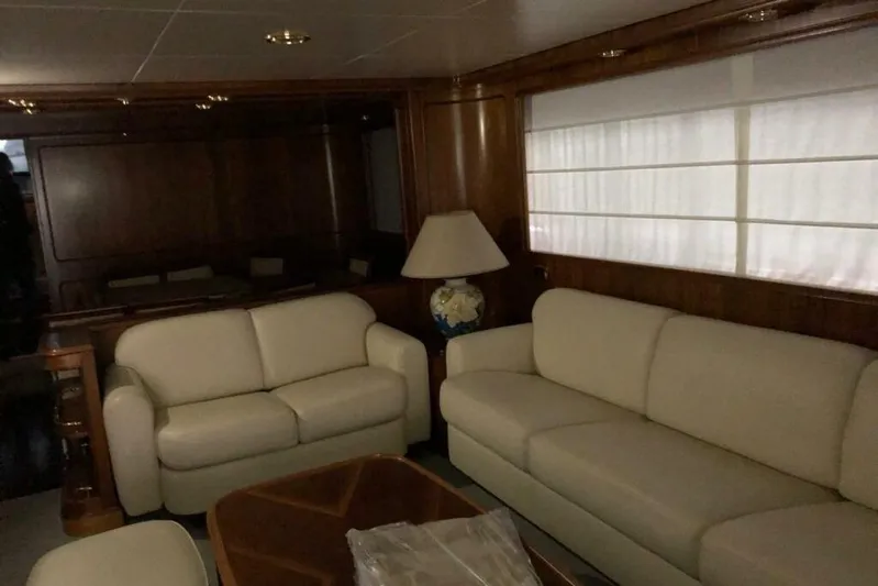  Yacht Photos Pics Luxurious interior of 1998 Sanlorenzo 82 yacht with cream sofas and wooden accents.