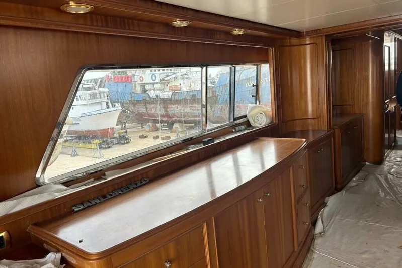  Yacht Photos Pics Luxurious wooden interior of a 1998 Sanlorenzo 82 yacht with large window view.