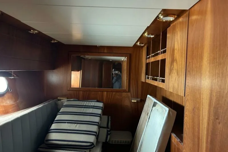  Yacht Photos Pics Luxurious wooden interior of 1998 Sanlorenzo 82 yacht cabin with striped cushions.