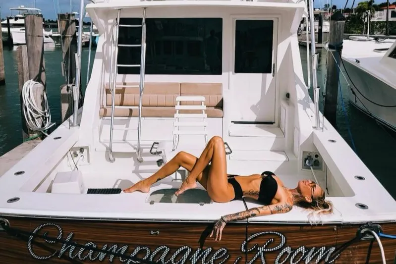  Yacht Photos Pics Woman sunbathing on 1998 Viking 53 Convertible yacht named "Champagne Room" at marina.