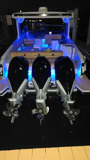  Yacht Photos Pics 2021 Aviara AV36 OB boat with triple outboard engines and blue LED lighting at night.