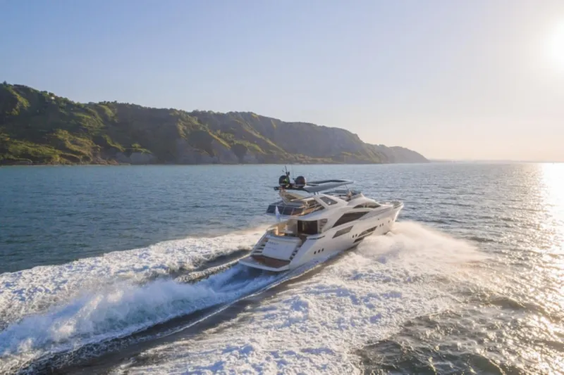  Yacht Photos Pics Luxurious 2015 Dominator 800 yacht cruising near scenic coastline at sunset.