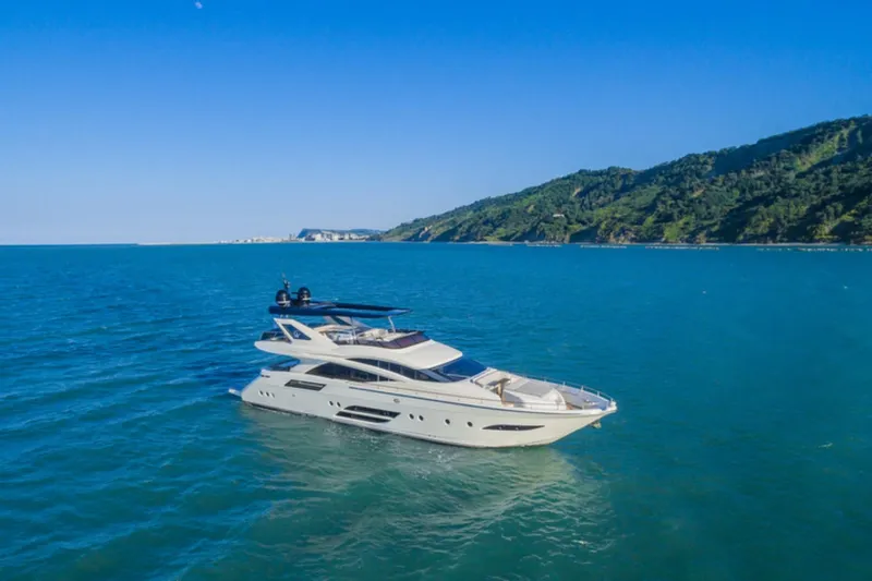  Yacht Photos Pics Luxury yacht Dominator 800 (2015) cruising on blue ocean near lush coastline.