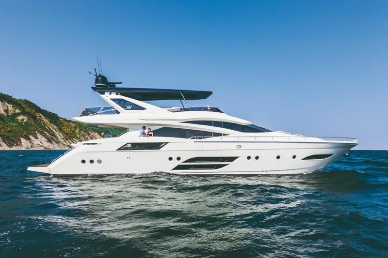  Yacht Photos Pics Luxurious 2015 Dominator 800 yacht cruising on open sea near scenic coastline.