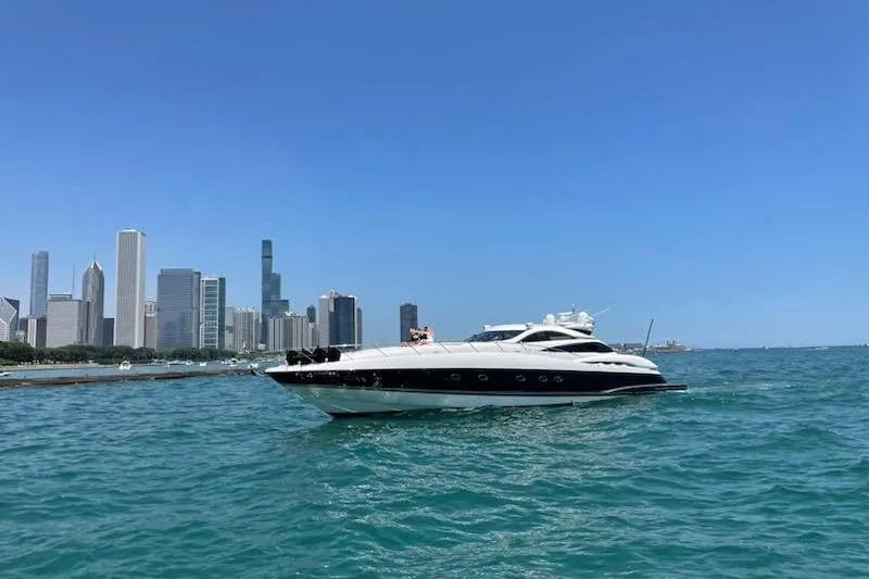 Vintage Yacht Photos Pics Sunseeker Predator 75 yacht on water with city skyline in background, 1999 model.