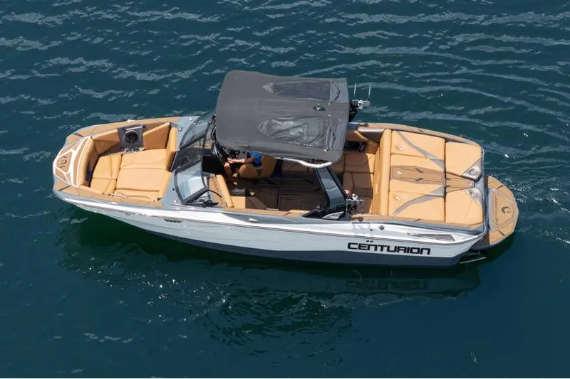  Yacht Photos Pics 2025 Centurion Nv233 boat on water, featuring tan seating and black canopy.