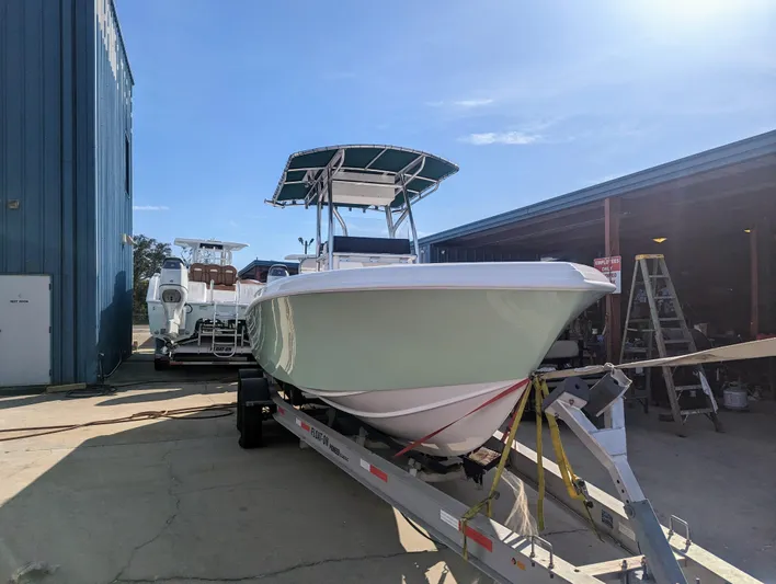  Yacht Photos Pics 2023 Bluewater Sportfishing 23t boat on trailer, parked outside a warehouse.
