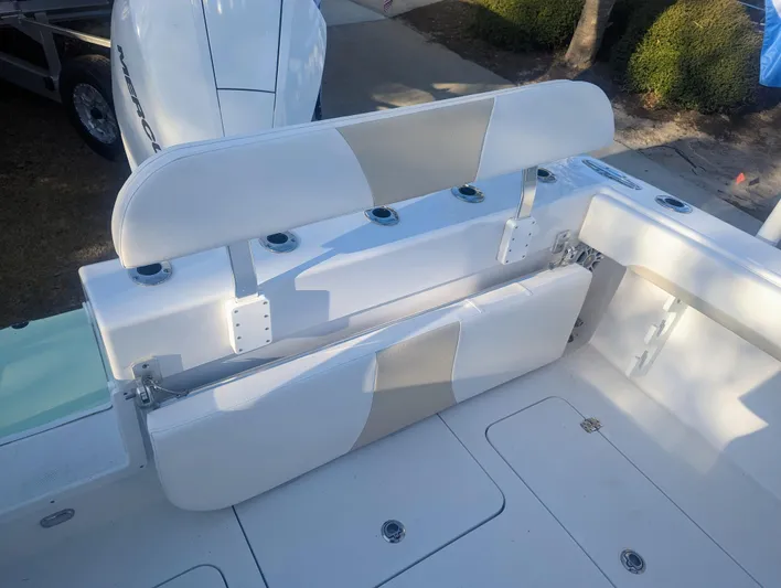  Yacht Photos Pics 2023 Bluewater Sportfishing 23t boat seating area with white cushioned seats and rod holders.