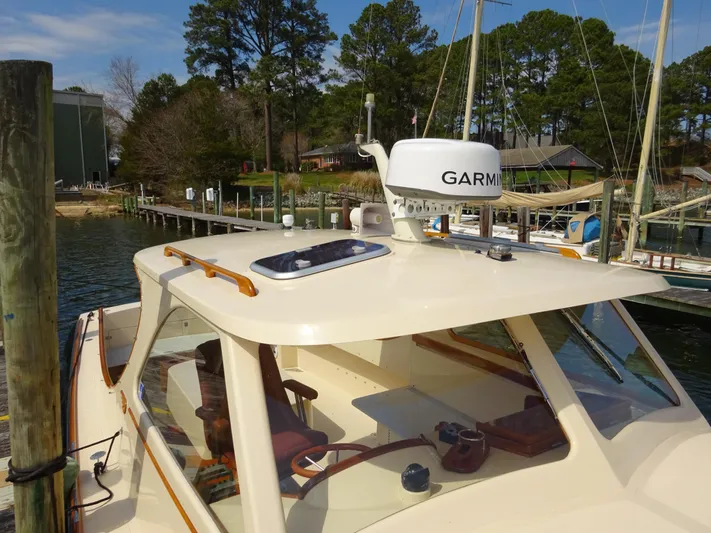 Blue Moon Yacht Photos Pics 1995 Hinckley Picnic Boat Classic docked, featuring Garmin equipment, surrounded by trees and water.