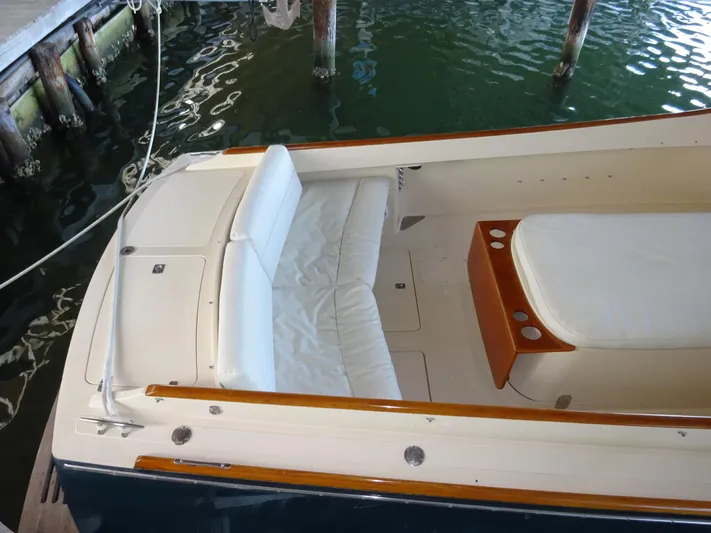 Blue Moon Yacht Photos Pics 1995 Hinckley Picnic Boat Classic with white seating, docked in calm waters.