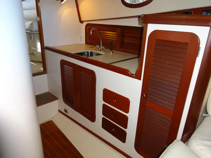 Blue Moon Yacht Photos Pics 1995 Hinckley Picnic Boat Classic interior with wooden cabinetry and compact kitchen area.