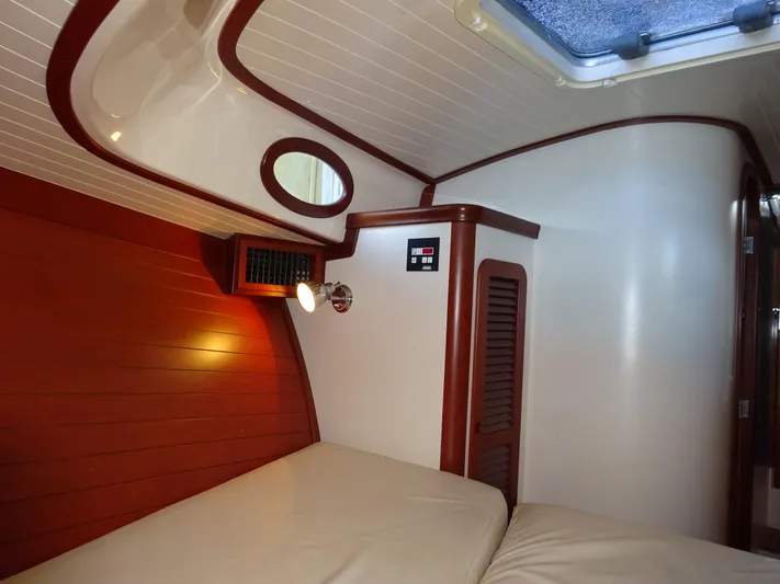 Blue Moon Yacht Photos Pics Interior cabin of 1995 Hinckley Picnic Boat Classic with wood paneling and cozy bed.