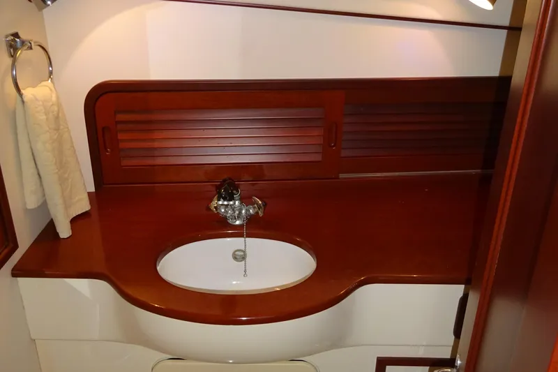 Blue Moon Yacht Photos Pics Elegant wooden bathroom interior of 1995 Hinckley Picnic Boat Classic, featuring a sleek sink and towel holder.
